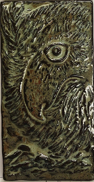 This tile shows the face of an owl with one eye turned towards the viewer.