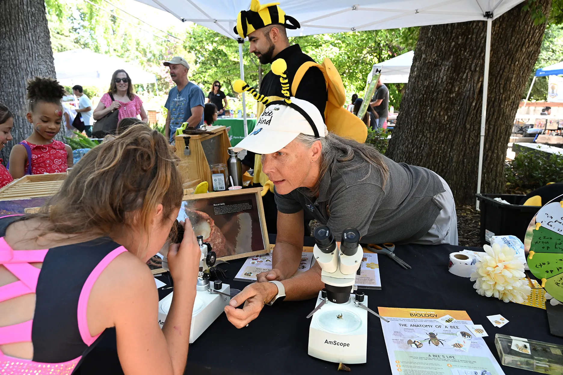 Wendy Mather (foreground) and Kian Nikzad (background, in bee costume) and CAMBP member Rick Moehrke (in blue shirt) talk to the crowd during CAMBP's program at the Children's Party at the Vacaville Museum. (Photo by Kathy Keatley Garvey)