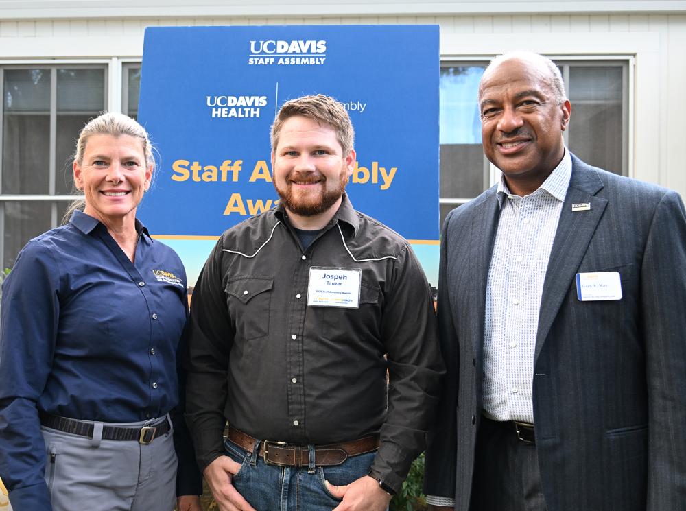 Ashley Stokes, dean of the UC Davis College of Agricultural and Environmental Sciences, award recipient Joseph Tauzer and Chancellor Gary May pose for a photo. (Photo by Kathy Keatley Garvey)