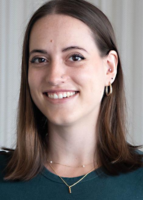 Headshot of a smiling young woman with brown hair, green top, and gold jewelrylin