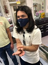 Imagine Morales holding a hissing cockroach