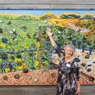 UC Davis distinguished professor Diane Ullman in front of the "Secret Life of Vineyards," created by the students in Entomology 001. It graces  an outer wall of the Matthiasson Winery on Dry Creek Road, Napa.