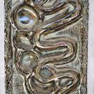 This design shows intertwining circles with a snake, symbols from the Zuni culture.