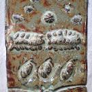 This tile shows the metamorphosis of an insect in stages from the top of the tile to the bottom.