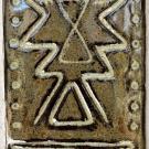 This tile shows an indigenous symbol for the thunderbird in the center with lines in decreasing size underneath.
