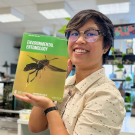 UC Davis alumna RJ Millena, doctoral candidate at the Richard Gilder Graduate School, American Museum of Natural History, holds the August issue of the journal 'Environmental Entomology."  Her research made the cover.